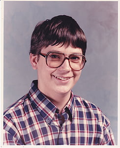 man in red, blue, and gray plaid button-up top thumbnail