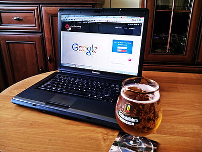 black Toshiba laptop computer beside wine glass thumbnail