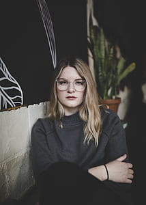 woman sitting near green snake plant with brown pot thumbnail