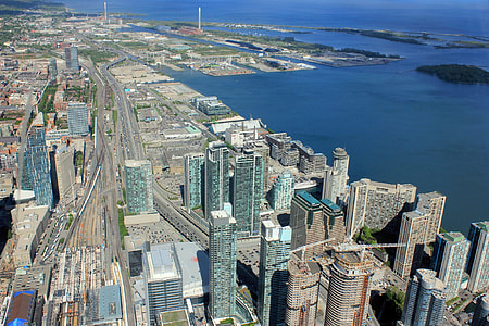 aerial photo of high-rise glass buildings near sea water under blue sky thumbnail