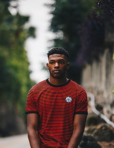man standing and wearing red and white striped shirt in focus photography thumbnail