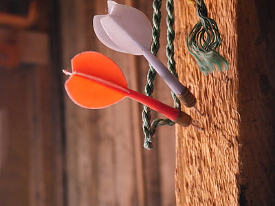 two white and orange dart pins on wall thumbnail