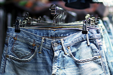 blue denim jeans hanged on silver hangers thumbnail