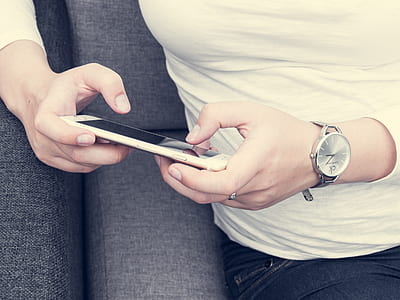woman sitting on sofa holding phone thumbnail