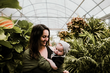 shallow focus photography of woman carrying baby during daytime thumbnail