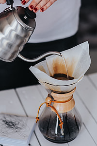 Woman pouring water in Chemex filter coffee maker thumbnail
