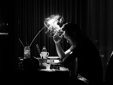 man smoking and sitting in front of desk thumbnail