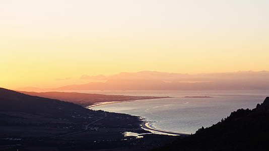 silhouette of mountain near ocean during golden hour thumbnail