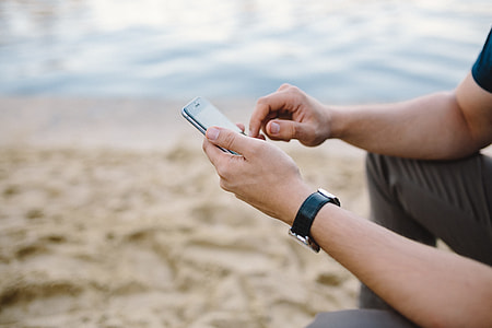 Young Man Using His Phone on beach thumbnail