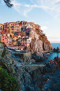 brown village on mountain near body of water thumbnail