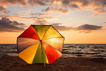 multicolored umbrella on seashore thumbnail