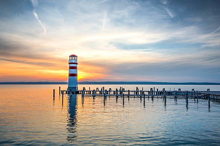 white and red lighthouse at the end of dock thumbnail