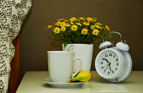 white alarm clock and white ceramic mug on top of white table thumbnail