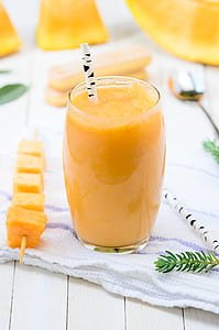 fruit shake inside clear drinking glass with disposable straw thumbnail