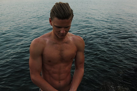 man standing in front of body of water thumbnail