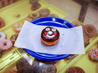 A smiley face donut sitting on a blue plate. thumbnail