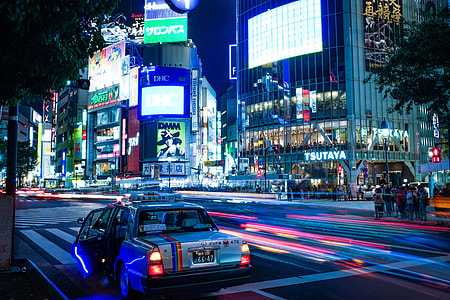 sedan parks near buildings during nighttime thumbnail