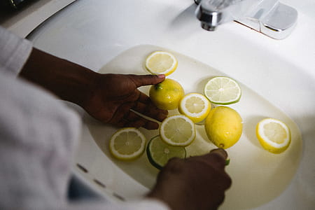 person dipping sliced citrus fruits in sink thumbnail