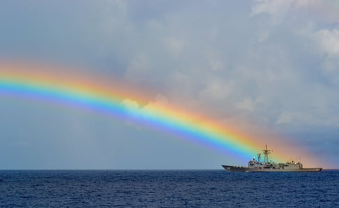sailing ship on rippling body of water under rainbow thumbnail
