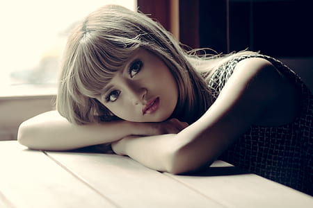 woman wearing black top with bangs hair putting her arms on table thumbnail