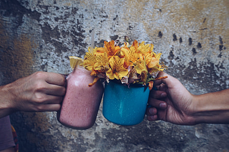 person holding blue jar with yellow flowers thumbnail