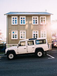 white SUV parked on grey top road beside grey wooden house on daytime thumbnail