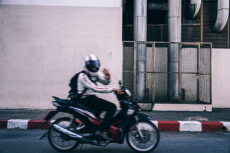 man riding motorcycle while waving to his right thumbnail
