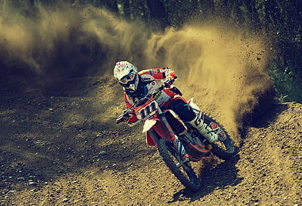 man riding white and orange 111 motocross dirt bike on road thumbnail