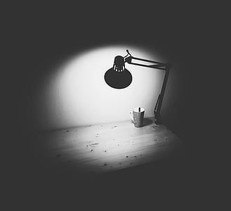 grayscale photo of desk lamp on table thumbnail