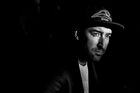 Grayscale Photo Portrait of Man in Black Cap thumbnail