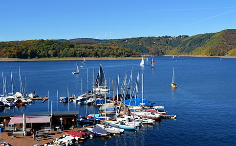boats docked on body of water near shed thumbnail