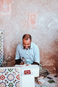 man sitting near wall smiling thumbnail