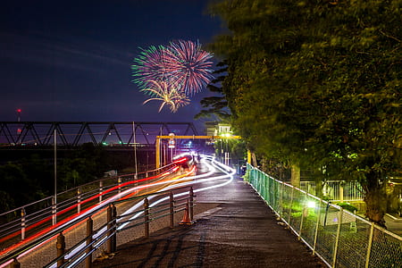 long exposure photography if fireworks over road and bridge thumbnail