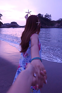 woman in blue sleeveless dress walking near shore thumbnail