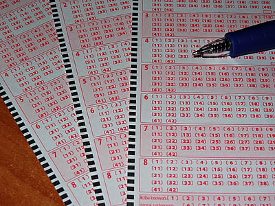 blue pen on top of three lottery tickets thumbnail