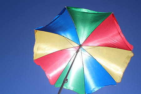 green, blue, and red umbrella under the sun thumbnail