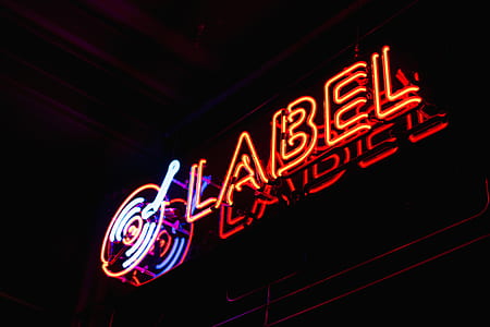 Label neon light signage on board at nighttime thumbnail