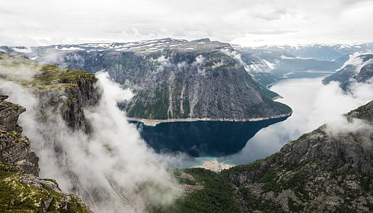 body of water in the middle of mountain during daytime thumbnail