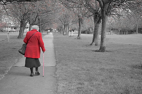 woman in red long-sleeved top walking on gray concrete road thumbnail