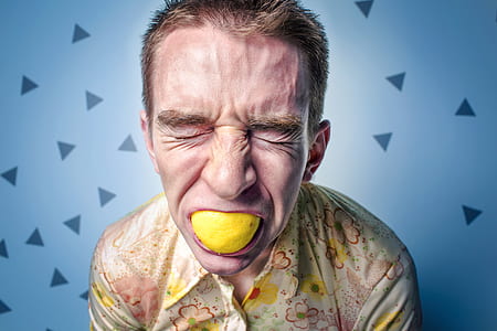 close up photography man eating lemon thumbnail