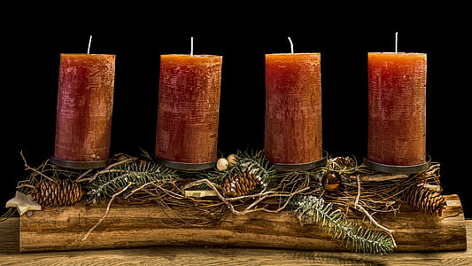 four brown pillar candles on brown wooden holder thumbnail