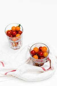 two clear glass containers with red and orange fruits thumbnail
