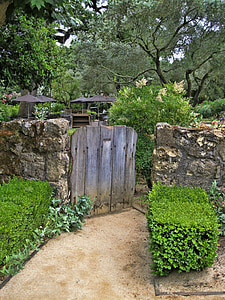brown wooden gate mounted on concrete wall towards garden thumbnail
