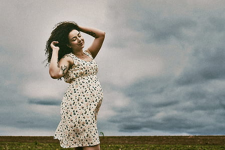 woman raising her both hands while standing on the field thumbnail