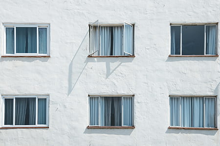 minimalist photography of six glass windows with gray curtains thumbnail