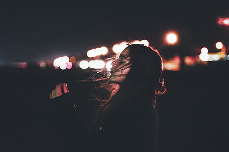 close up photo of woman stand near lighted city skyline thumbnail