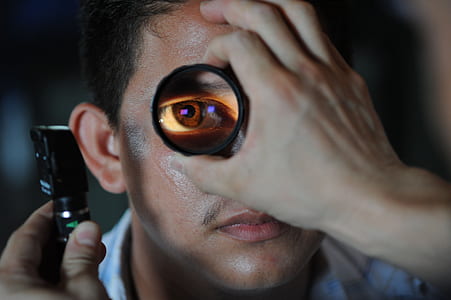 closeup photo of man showing his eye with magnifying glass thumbnail