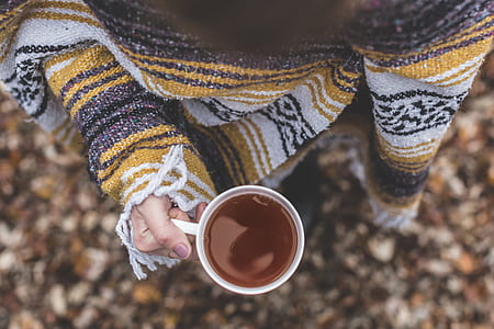 person in sweater holding a filled mug thumbnail