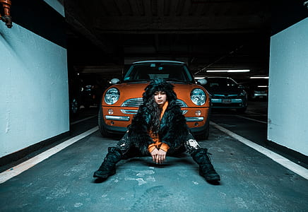 woman sitting in-front of Mini Cooper on parking lot thumbnail