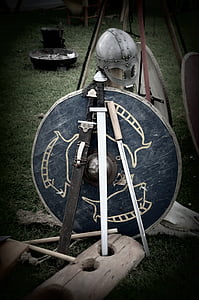black handled sword with blue shield behind thumbnail